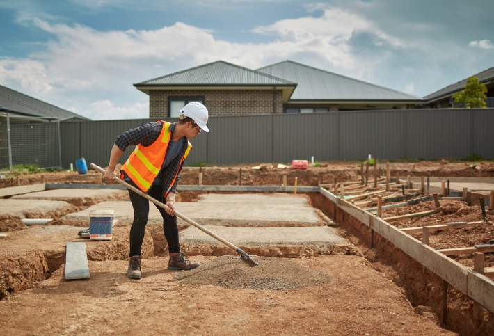 Tradesman on building site working with the slab of the house, before use of impact soil testing