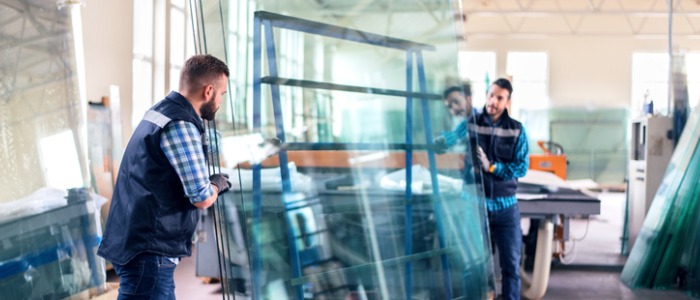 two workers carrying safety glass for testing